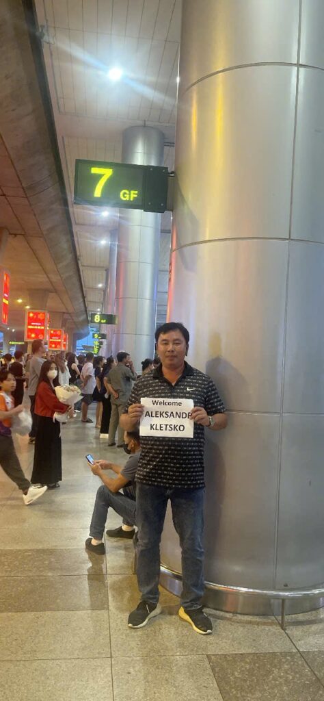 Водитель Bao Chung Travel встречает пассажира в аэропорту с именной табличкой